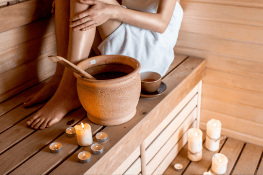 A relaxed sauna setting with timber benches, towels and candles
